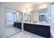 Elegant bathroom featuring dual vanities, a soaking tub, and marble tile at 8775 W Lane Ave, Glendale, AZ 85305