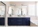 Modern bathroom featuring dual sinks, dark blue vanity, and bright lighting at 8775 W Lane Ave, Glendale, AZ 85305