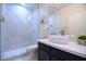 Modern bathroom with marble tile, glass shower, and dark wood vanity at 8775 W Lane Ave, Glendale, AZ 85305