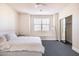 Bedroom with a white bed, large window, and mirrored closet doors at 8775 W Lane Ave, Glendale, AZ 85305