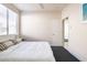 Spacious bedroom with white walls, white bedding, and large window with blinds at 8775 W Lane Ave, Glendale, AZ 85305
