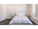 Simple bedroom with white bedding, minimalist nightstands, and neutral walls at 8775 W Lane Ave, Glendale, AZ 85305