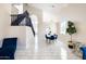 Dining room with blue velvet furniture, white tile floor, and view of the staircase at 8775 W Lane Ave, Glendale, AZ 85305