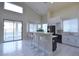Modern kitchen with white cabinets, black appliances, an island with bar seating, and backyard access at 8775 W Lane Ave, Glendale, AZ 85305