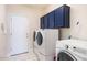 Laundry room with a Whirlpool washer and dryer and overhead cabinets at 8775 W Lane Ave, Glendale, AZ 85305