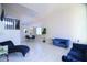 Open-concept living space with stylish blue furniture, tile flooring, and ample natural light at 8775 W Lane Ave, Glendale, AZ 85305