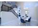 The dining area features a white table with blue chairs, a stylish light fixture, and a view of the staircase at 8775 W Lane Ave, Glendale, AZ 85305