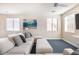 Living room with white sectional sofa, blue carpet, and ocean-themed wall art at 8775 W Lane Ave, Glendale, AZ 85305
