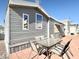 Home's exterior featuring gray siding, a patio area with a table and chairs, and surrounding landscaping at 99 S Kaoline Dr, Apache Junction, AZ 85119