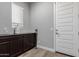 Laundry room with dark brown cabinets and vinyl plank flooring at 10157 E Texas Ave, Mesa, AZ 85212