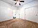 Spacious bedroom with neutral carpet, white walls, ceiling fan, and a large closet at 1627 S 104Th Ln, Tolleson, AZ 85353