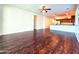 Open-concept living area with wood-look flooring, a ceiling fan, and adjacent kitchen at 1627 S 104Th Ln, Tolleson, AZ 85353