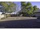 Spacious gravel backyard with trees, landscaping, and a sitting area at 3018 N Regal Ct, Casa Grande, AZ 85122