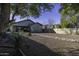 Large backyard with gravel landscaping, a covered patio, and mature trees at 3018 N Regal Ct, Casa Grande, AZ 85122