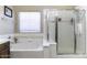 Bathroom with white tile, glass shower doors, and a bathtub at 3018 N Regal Ct, Casa Grande, AZ 85122