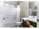Clean bathroom with white tile, wooden cabinets, and a shower/tub combo at 3018 N Regal Ct, Casa Grande, AZ 85122