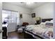 Spacious bedroom with wood floors, a colorful quilt, a sitting area, and ample natural light at 3018 N Regal Ct, Casa Grande, AZ 85122