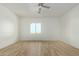 Empty bedroom with wood-look floor, ceiling fan, and large window at 30432 N 235Th Ln, Wittmann, AZ 85361