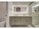 Bathroom with dual vanity featuring brass fixtures and green cabinets at 3335 E San Angelo Ave, Gilbert, AZ 85234