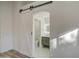 View of the bathroom through an open barn door from the bedroom at 3335 E San Angelo Ave, Gilbert, AZ 85234