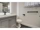 Bathroom featuring gray vanity, single sink, toilet, and black accents at 3335 E San Angelo Ave, Gilbert, AZ 85234