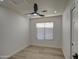 Bright bedroom with wood-look flooring, ceiling fan, and window with blinds at 3335 E San Angelo Ave, Gilbert, AZ 85234