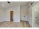Bedroom featuring wood-look floors, barn door, walk-in closet, and standard door at 3335 E San Angelo Ave, Gilbert, AZ 85234