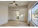 Bright bedroom with wood-look flooring, barn door, and large window at 3335 E San Angelo Ave, Gilbert, AZ 85234