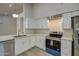 Modern white kitchen with stainless steel appliances, marble counters, and gold fixtures at 3335 E San Angelo Ave, Gilbert, AZ 85234