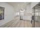 Open-concept kitchen and living area with white cabinets, stainless steel appliances, and wood-look floors at 3335 E San Angelo Ave, Gilbert, AZ 85234