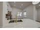 Modern kitchen featuring white cabinets, marble countertops, and gold faucet at 3335 E San Angelo Ave, Gilbert, AZ 85234