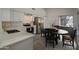Modern kitchen with white cabinets, stainless steel appliances, and a dining area at 3335 E San Angelo Ave, Gilbert, AZ 85234