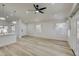 Open and airy living room with wood-look flooring, ceiling fan, and ample natural light at 3335 E San Angelo Ave, Gilbert, AZ 85234