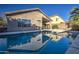 Sparkling blue pool with a reflection of the house and clear skies at 3335 E San Angelo Ave, Gilbert, AZ 85234