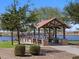 Community lake with ramada, picnic tables, and waterfall at 36971 W Prado St, Maricopa, AZ 85138