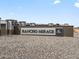 Rancho Mirage community entrance sign with stone accents and decorative fencing at 37028 W Prado St, Maricopa, AZ 85138