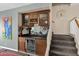 Dry bar with wine rack, granite countertop, and wood cabinets located next to the staircase at 4208 E Tether Trl, Phoenix, AZ 85050