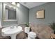 Half bathroom with pedestal sink, tiled walls, and decorative mirror at 4208 E Tether Trl, Phoenix, AZ 85050