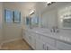 Double vanity bathroom with modern light fixtures and white cabinets at 501 E Desert Hills Estate Dr, Phoenix, AZ 85086