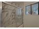Updated bathroom with a shower/tub combo and marble tile at 501 E Desert Hills Estate Dr, Phoenix, AZ 85086