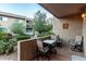 Tiled patio featuring an outdoor dining set, surrounded by lush greenery, trees, and desert landscaping at 7436 E Chaparral Rd # B162, Scottsdale, AZ 85250