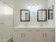 Dual vanity bathroom with white cabinets, mirrors, and a textured glass shower door at 80 N Bradley Dr, Chandler, AZ 85226