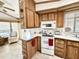 Kitchen with wood cabinets, white appliances, and a stovetop at 822 S Beryl Dr, Apache Junction, AZ 85119