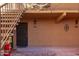 Close-up view of condo entrance with metal security door, festive decor, and upper-level balcony at 8500 E Indian School Rd # 129, Scottsdale, AZ 85251