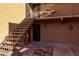 Ground-level view of condo exterior with stairs to upper units, decorative accents, and festive decor at 8500 E Indian School Rd # 129, Scottsdale, AZ 85251