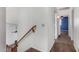 Hallway leading to a bedroom, featuring carpeted flooring and a wooden handrail at 8820 W Bloomfield Rd, Peoria, AZ 85381