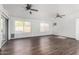 Bright living room with wood-look flooring, ceiling fans, and several windows at 8820 W Bloomfield Rd, Peoria, AZ 85381