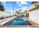 In-ground pool with brick surround, a white privacy wall, and a pergola with outdoor dining at 101 E Echo Ln, Phoenix, AZ 85020