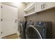 Laundry room with white cabinets, shelving, and black washer and dryer at 10731 E Texas Ave, Mesa, AZ 85212