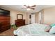 Primary bedroom featuring a comfortable bed, ceiling fan, and access to the ensuite bathroom at 1270 W Beacon Ct, Casa Grande, AZ 85122